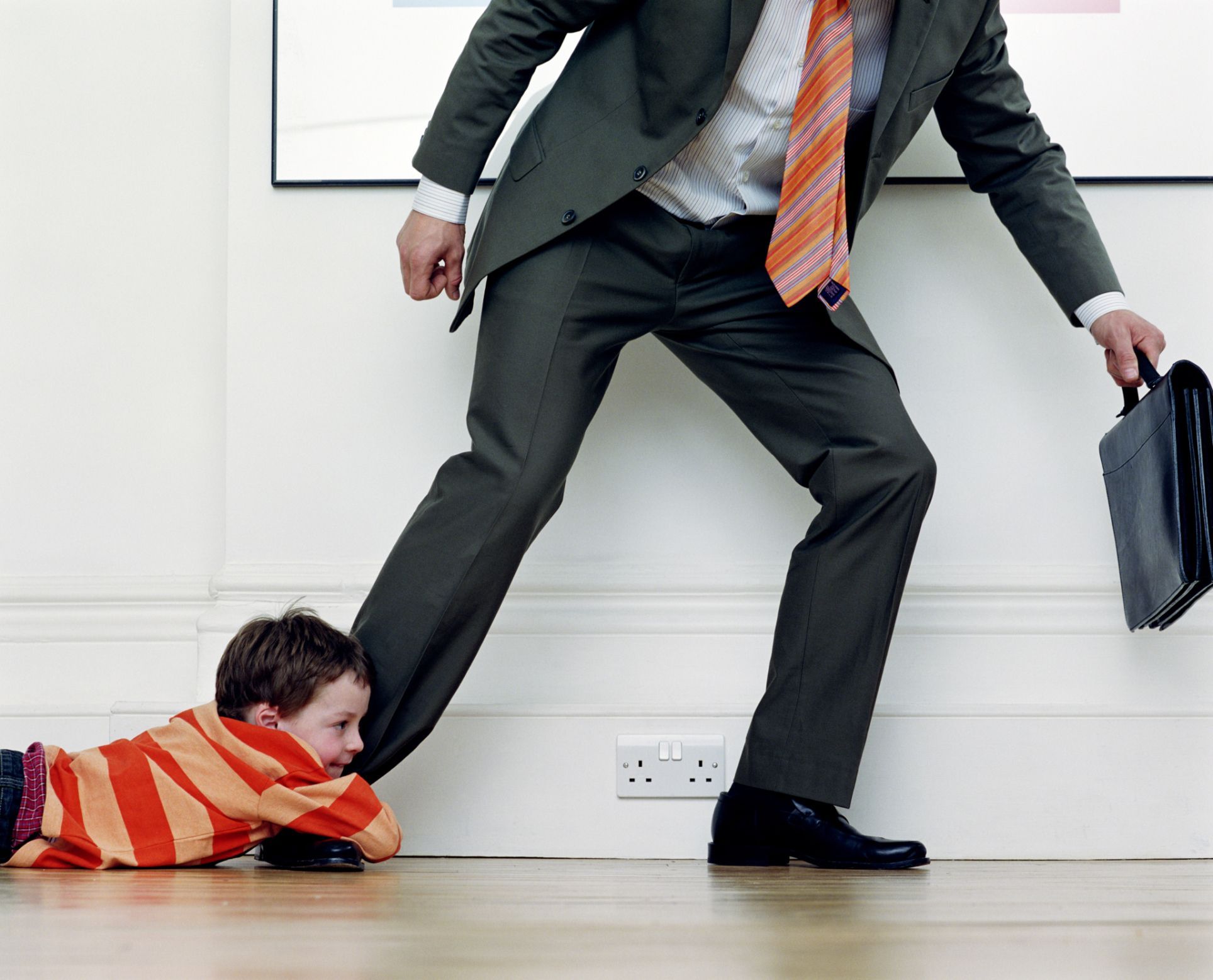 boy-7-9-holding-onto-businessman-s-leg-56a437913df78cf7728152ce